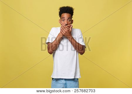 Attractive Young Dark-skinned Male Having Stunned And Schocked Look With Hand Closing Mouth.