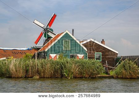 Traditional, Authentic Dutch Windmill At The River Zaam In Zaanse Schans Village.
