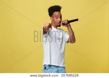 Attractive Young Dark-skinned Man With Afro Haircut In White T Shirt, Gesticulating With Hands And M