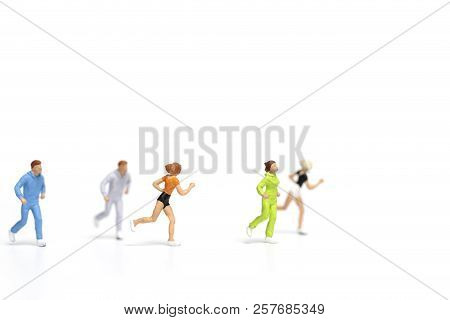 Miniature People Running On White Background , Healthy Lifestyle And Sport Concepts.