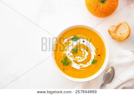 Pumpkin Soup With Cream And Pumpkin Seeds Isolated On White Background. Autumn Concept.