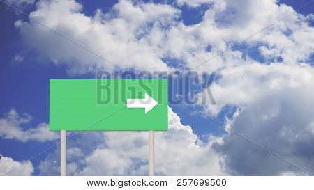 Green Road Sign With Arrow On Sky Background With Clouds