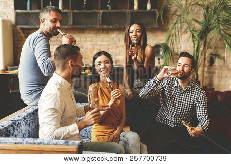 Spending Great Time With Best Friends. Group Of Cheerful Young People Enjoying Food And Drinks While
