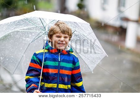 Beautiful Little Kid Boy On Way To School Walking During Sleet, Rain And Snow With An Umbrella On Co