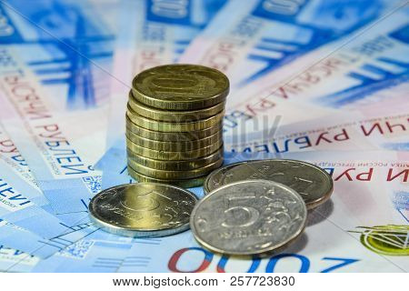 Russian Banknotes And Coins. A Handful Of Coins On New Russian Banknotes In Denominations Of 2000 An