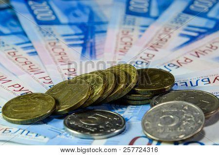 Russian Banknotes And Coins. A Handful Of Coins On New Russian Banknotes In Denominations Of 2000 An