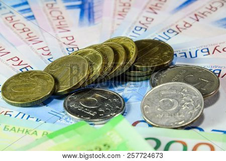 Russian Banknotes And Coins. A Handful Of Coins On New Russian Banknotes In Denominations Of 2000 An