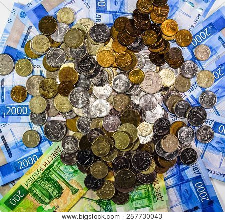Russian Banknotes And Coins. A Handful Of Coins On New Russian Banknotes In Denominations Of 2000 An