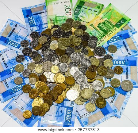Russian Banknotes And Coins. A Handful Of Coins On New Russian Banknotes In Denominations Of 2000 An