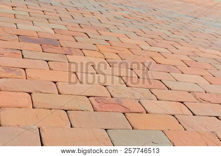 Pavement Made Of Red, Dark Red And Orange Bricks At Summer Day