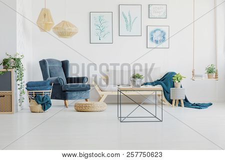 Metal Coffee Table In Front Of A Sofa And Comfy Armchair In A Bright Living Room Interior. Real Phot