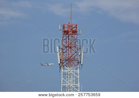 Mobile Phone Tower With Blue Sky And Airplane Background