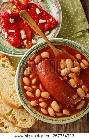 Bean Soup With Sausage Served With Pickled Pepper And Garlic Close-up. Vertical Top View