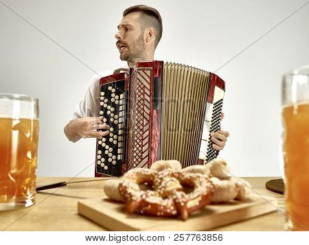 Man In Traditional Bavarian Clothes Playing Accordion. Germany, Bavaria, Upper Bavaria. The Young Ha