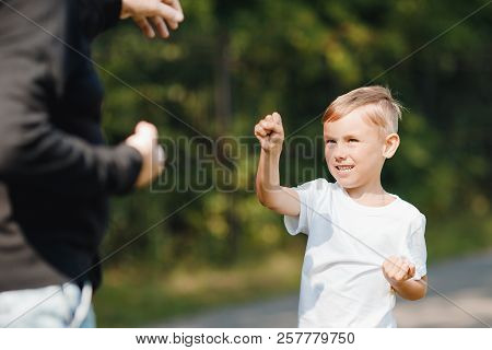Father Teaches Young Child Of Boy Son To Self-defense Techniques. Concept Hooligans School.
