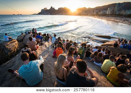 Rio De Janeiro, Brazil - August 18, 2018: People Sitting All Around On Arpoador Rock And Enjoying Be