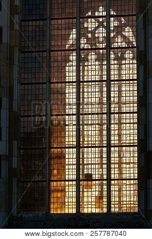 Last Sunlight From The Setting Sun Radiates Atmospherically Through Stained Glass Windows Of An Old 