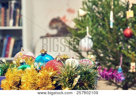 Christmas Balls And Tinsels Lying In A Box Near Chrictmas Tree