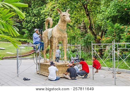 Phnom Penh, Cambodia - April 8, 2018: Workers  Making A Statue Out Of Braided Palm Leaves  In A Gard