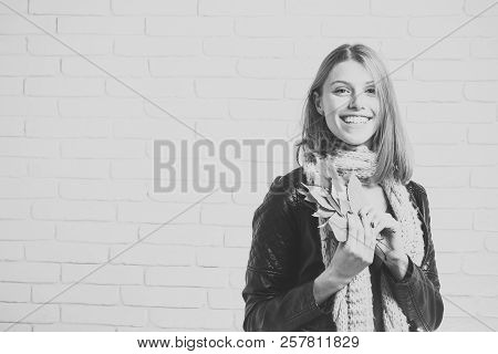 Season And Autumn Holiday. Beauty And Fashion. Girl With Orange Leaves At Brick Wall. Woman With Aut