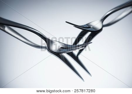 Close-up View Of Shiny Forks With Two Tines Reflected On Grey