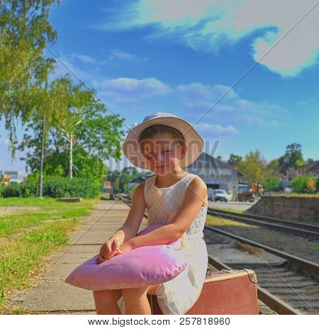 Adorable Little Girl On A Railway Station, Waiting For The Train With Vintage Suitcase. Traveling, H
