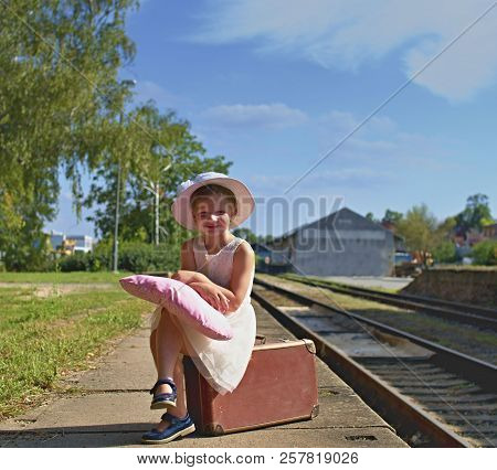 Adorable Little Girl On A Railway Station, Waiting For The Train With Vintage Suitcase. Traveling, H