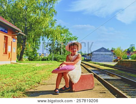Adorable Little Girl On A Railway Station, Waiting For The Train With Vintage Suitcase. Traveling, H