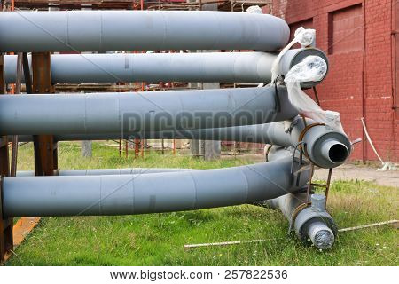 A Large Iron Metal Piping Trestle With Pipes And Electric Wires And Equipment At The Petrochemical R