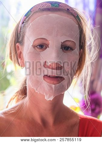 Girl with a cosmetic mask on her face