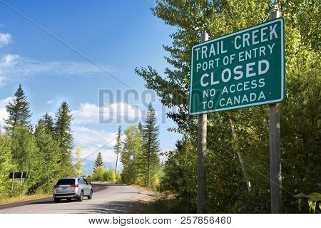 STATE HIGHWAY 486, MONTANA, USA: September 9, 2018: An SUV drives past a sign stating the Trail Creek Port of Entry is closed with no access to Canada