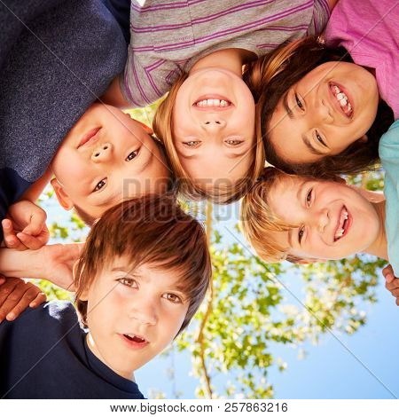Five schoolchildren standing in a circle and smiling