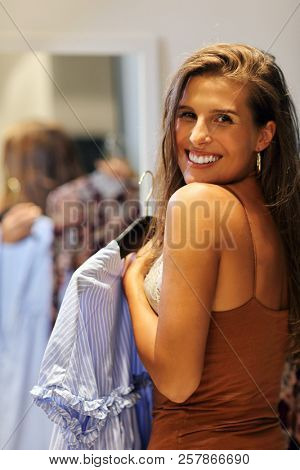 Beautiful woman thinking what to dress in walk-in closet