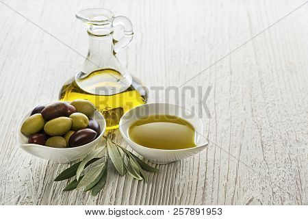 Bottle Of Extra Virgin Healthy Olive Oil With Fresh Olives On Wooden Background