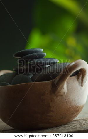 Close Up View Of Gray Spa  Lithotherapy  Stones On Green Color Back