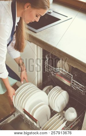 Dishwasher. Young woman in the Kitchen doing Housework. Wash-up