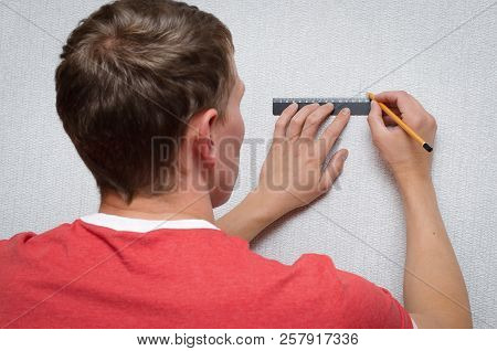 The Builder Marks On The Wall With A Ruler And Pencil The Dimensions For The Hole.