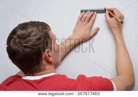 The Builder Marks On The Wall With A Ruler And Pencil The Dimensions For The Hole.