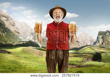 Germany, Bavaria. The Senior Happy Singing Man With Beer Dressed In Traditional Austrian Or Bavarian