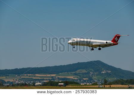 Zurich, Switzerland - July 19, 2018: Helvetic Swiss airlines airplane preparing for landing at day time in Zurich nternational airport