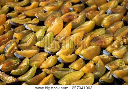 Plums Cut In Half Laid In Rows On A Tray To Dry