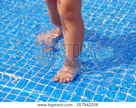 Feet In The Pool. Baby's Feet In Swimming Pool