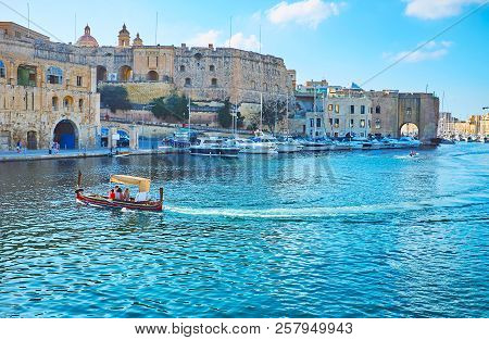 Birgu, Malta - June 17, 2018: The Dghajsa Water Taxi Is Traditional Maltese Wooden Boat, Offering Pl