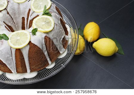 Whole Lemon Cream Cheese Bundt Cake With Slices Of Fresh Lemons And Mint On Top. Extreme Shallow Dep