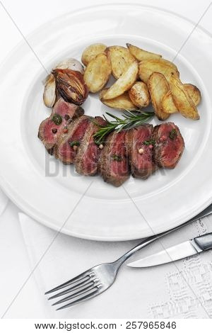 Dish Of Rosbeef And French Fries On A Plate