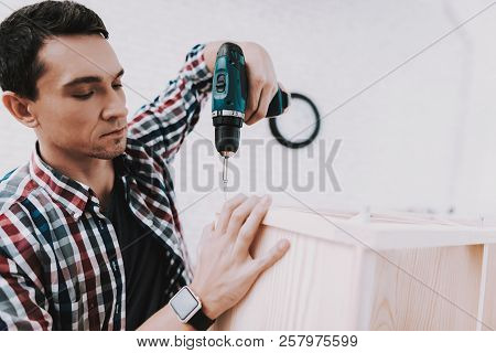 Young Man Assembling Wooden Bookshelf At Home. Wooden Bookcase. Selfmade Furniture. Man And Hobby. W