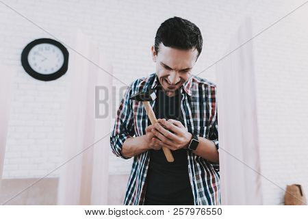 Young Man Injured When Assembling Wooden Bookshelf. Wooden Bookcase. Selfmade Furniture. Man And Hob