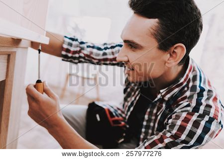 Young Man Assembling Wooden Bookshelf At Home. Wooden Bookcase. Selfmade Furniture. Man And Hobby. W