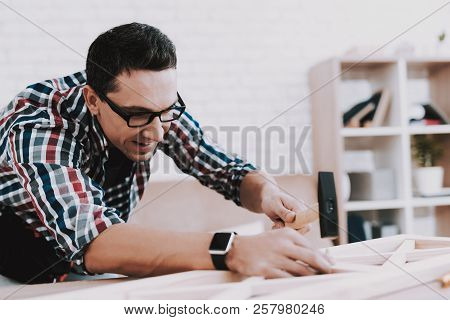 Young Man Assembling Wooden Bookshelf At Home. Wooden Bookcase. Selfmade Furniture. Man And Hobby. W