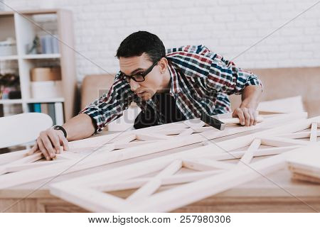 Young Man Assembling Wooden Bookshelf At Home. Wooden Bookcase. Selfmade Furniture. Man And Hobby. W